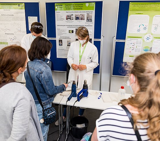 Besucher schauen sich ein Forschungsprojekt der Uni an