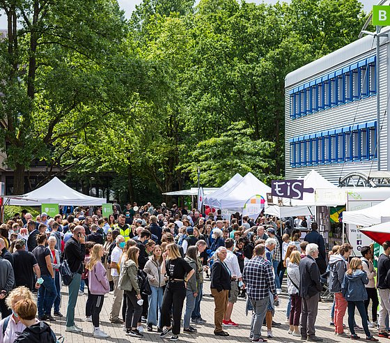 Menschen auf dem Vorplatz vor Gebäude B